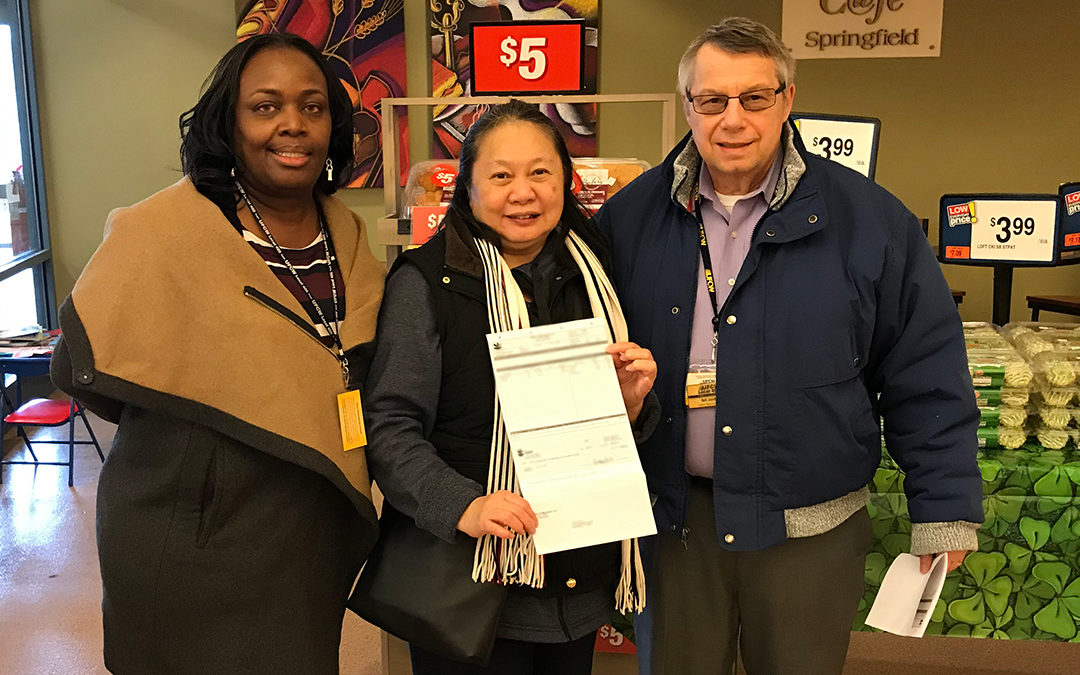 Loan Cao, a 29-year member of Local 400 from Giant Food, holds up her backpay check for a photo with union representatives Bertha McKiver (left) and Neil Jacobs (right).